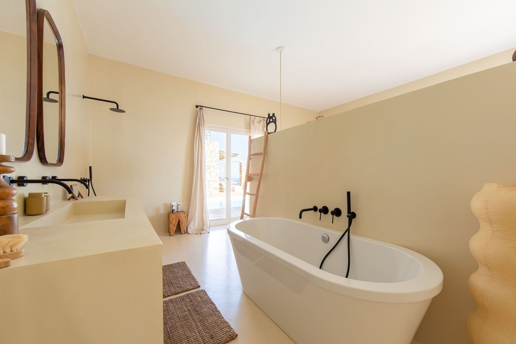 Freestanding bath beneath two round mirrors