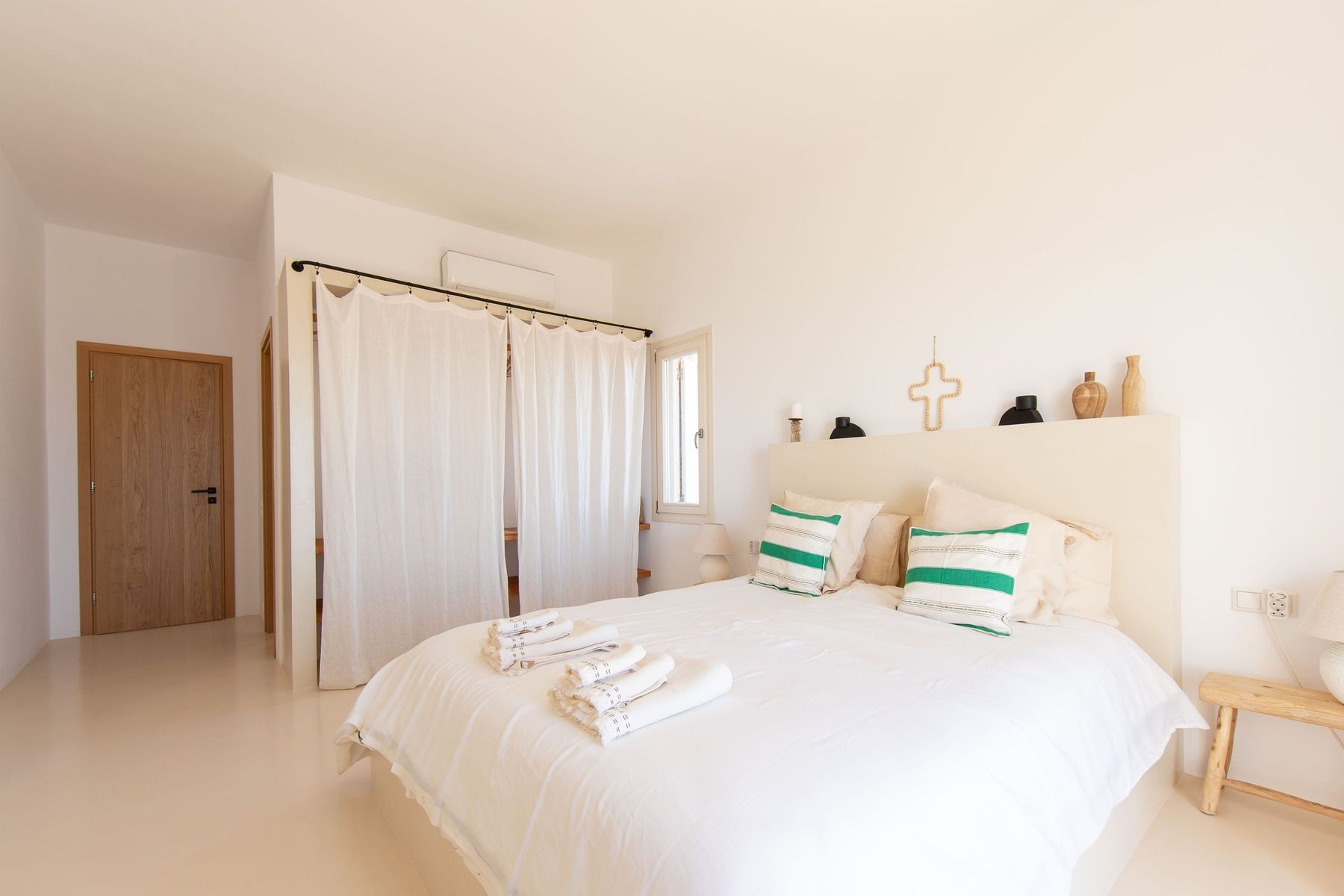 Bedroom with green-striped cushions, seen from the door
