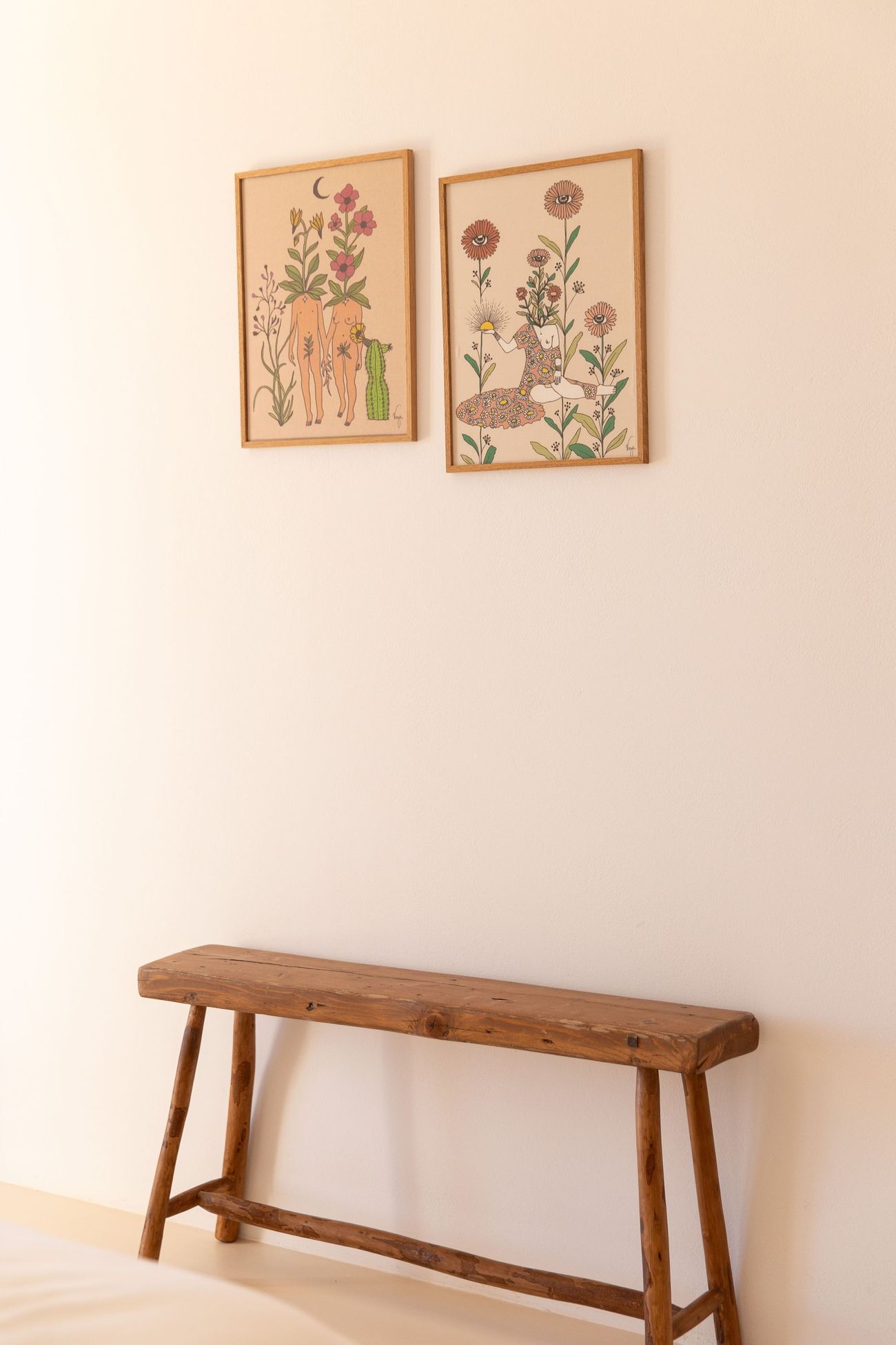 Framed botanical prints above a wooden bench