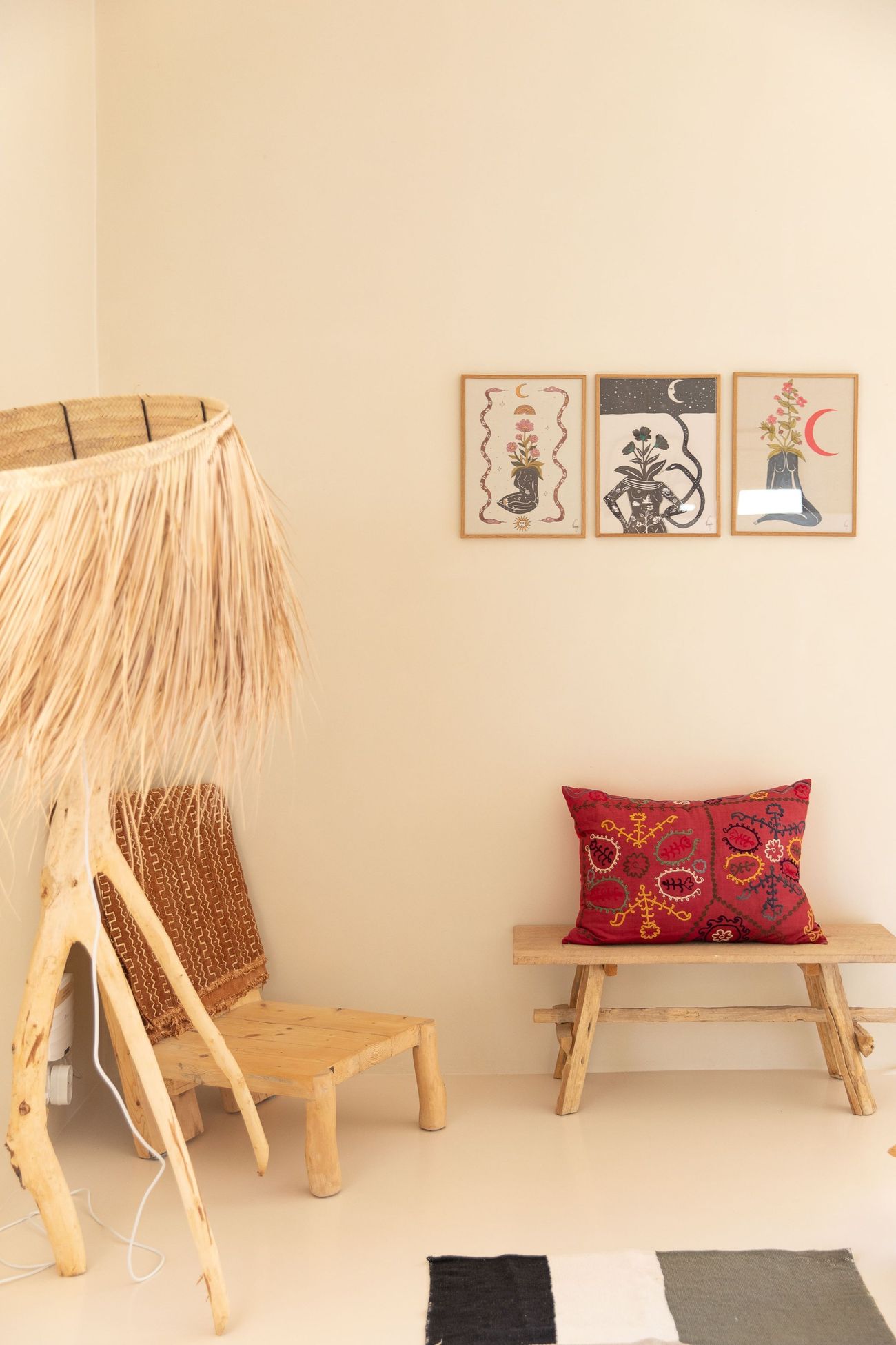 A carved chair and framed prints in a quiet corner