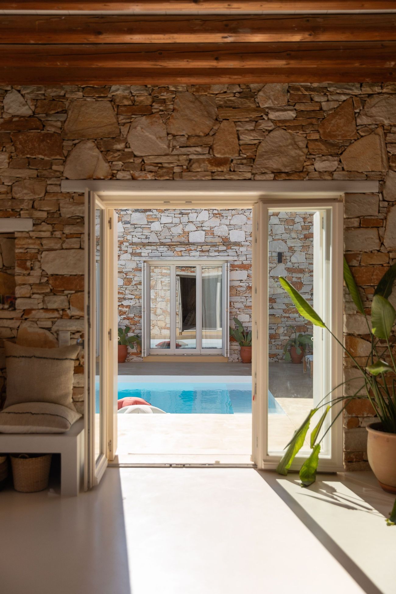 A doorway through the stone wall to the pool
