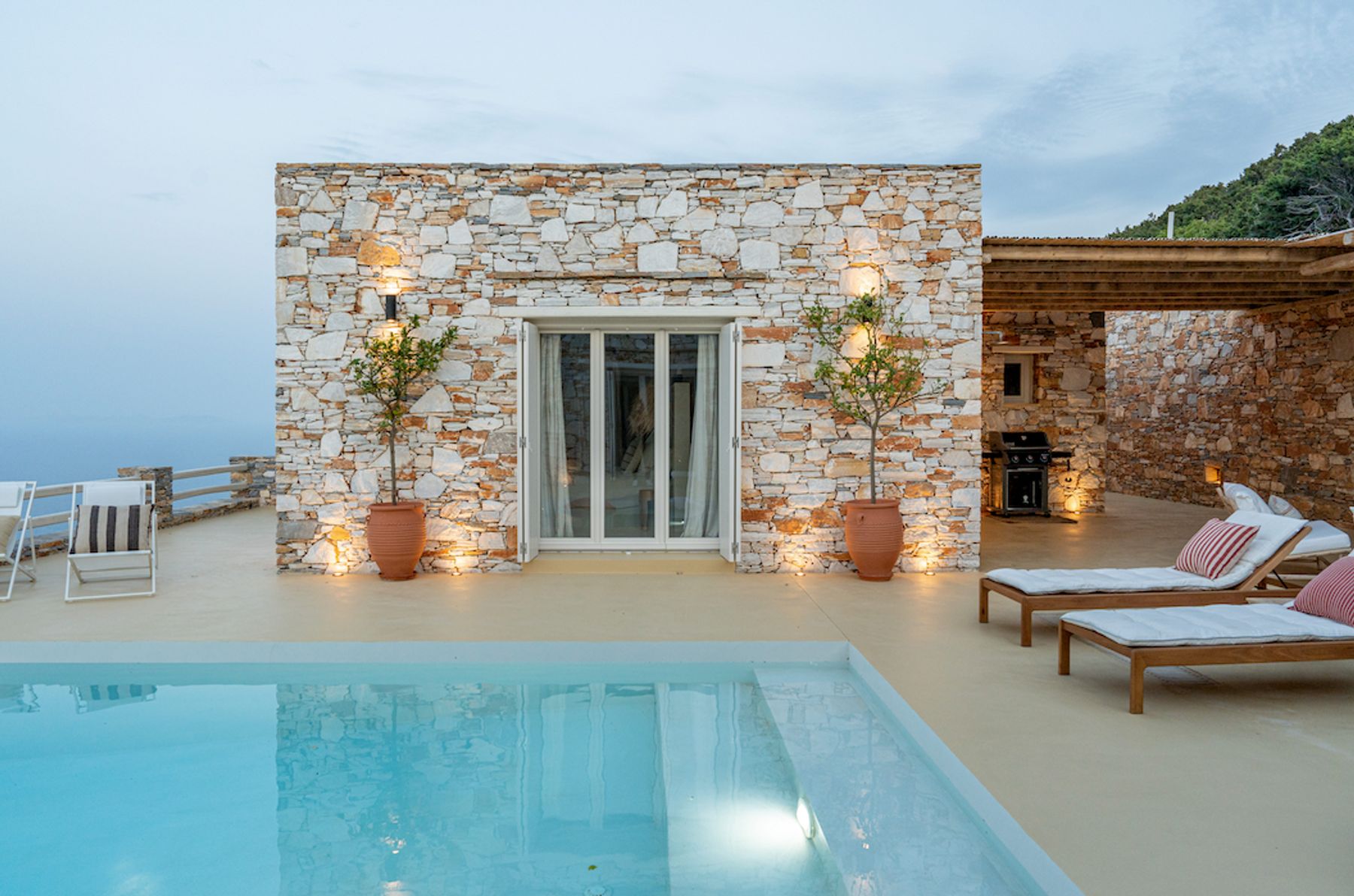 Stone facade and lit pool after sunset