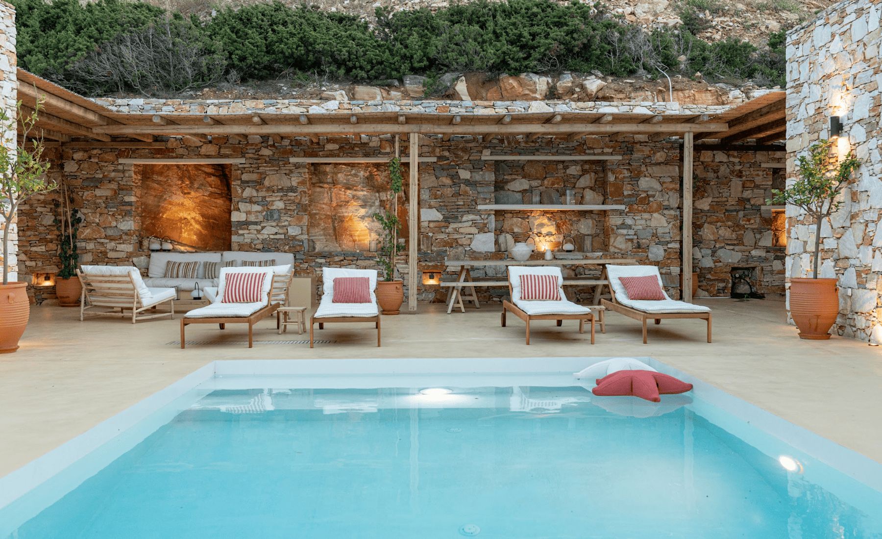 The pool and its loungers lit at dusk