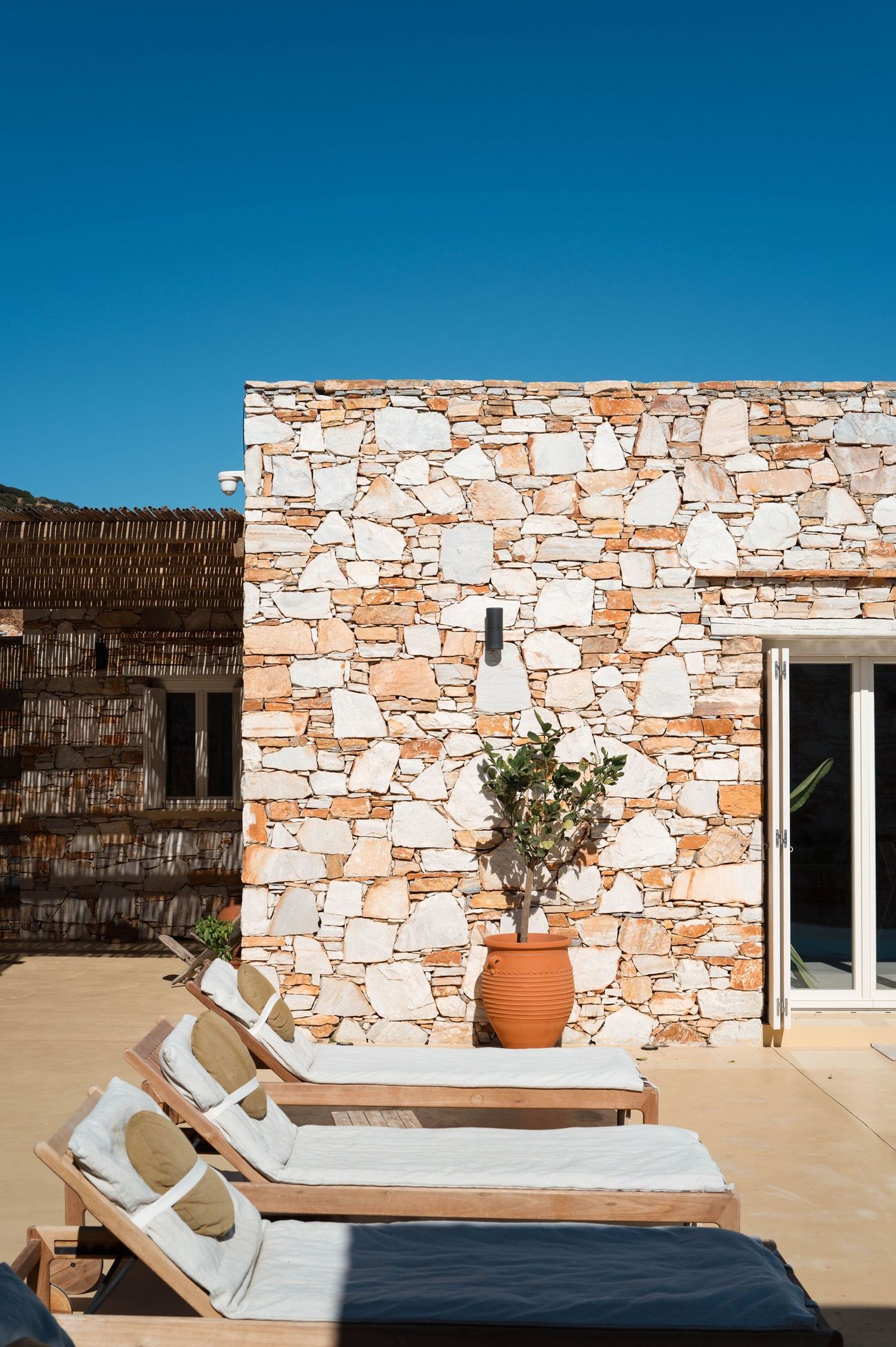 Loungers against the stone facade