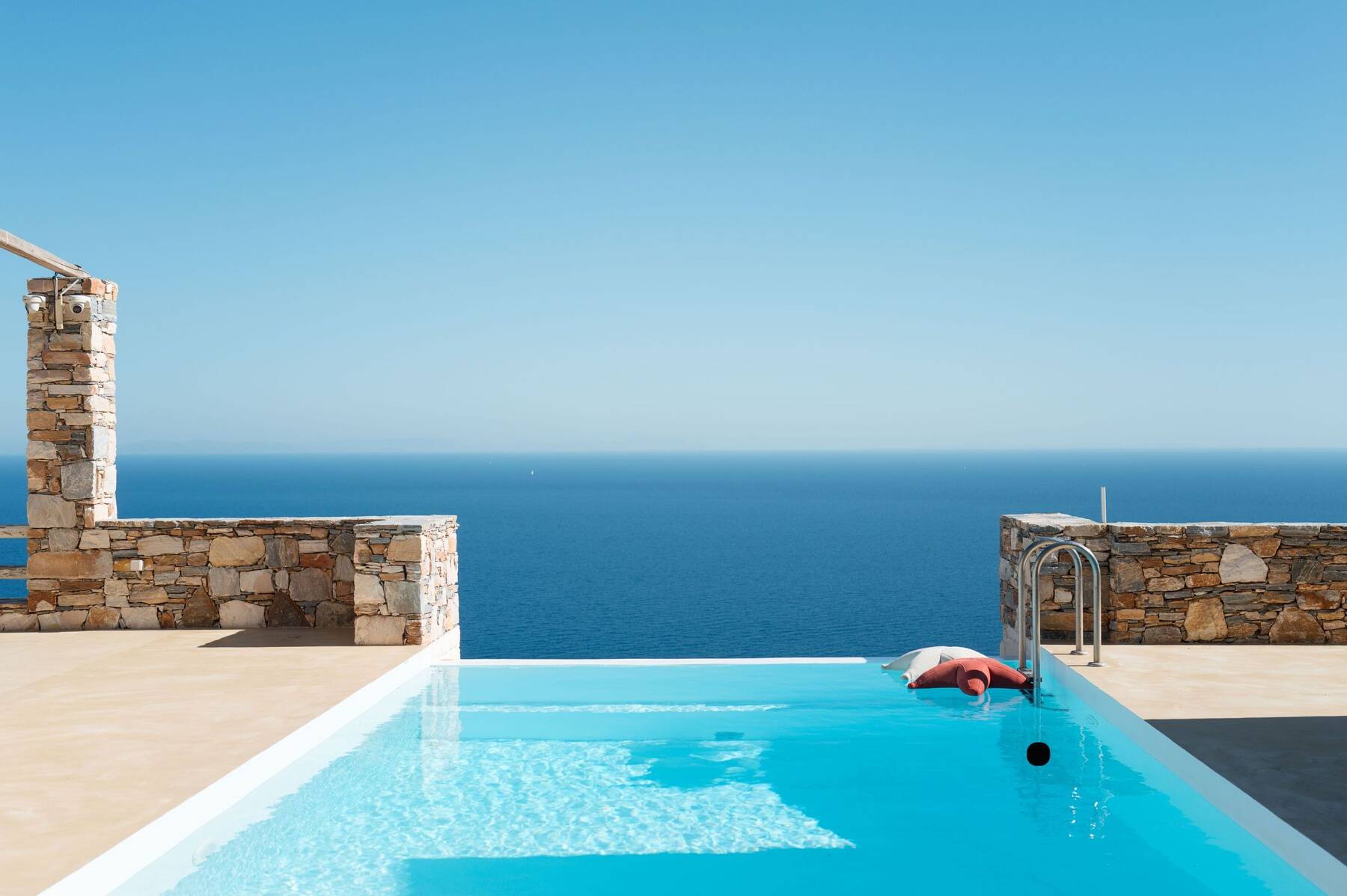 Infinity pool edge meeting the Aegean